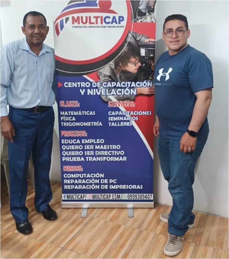 Equipo de MULTICAP junto al banner del centro
