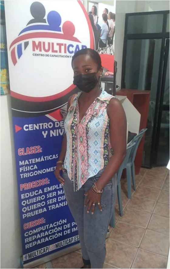 Estudiante junto al banner de servicios de MULTICAP